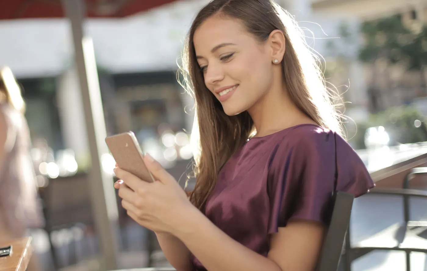 Frau freut sich über ihr Smartphone